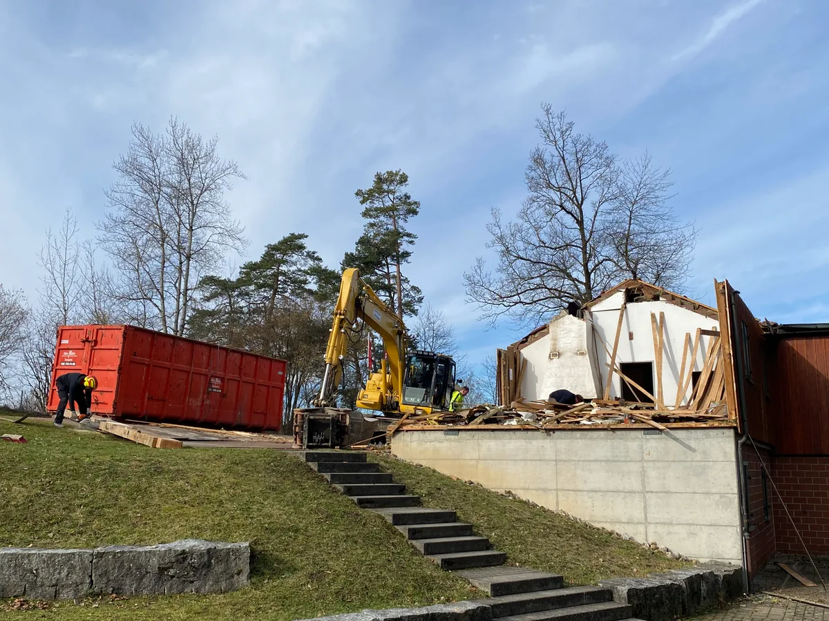 Ein Bagger arbeitet am Abbruch des Pfadiheims in Weisslingen.